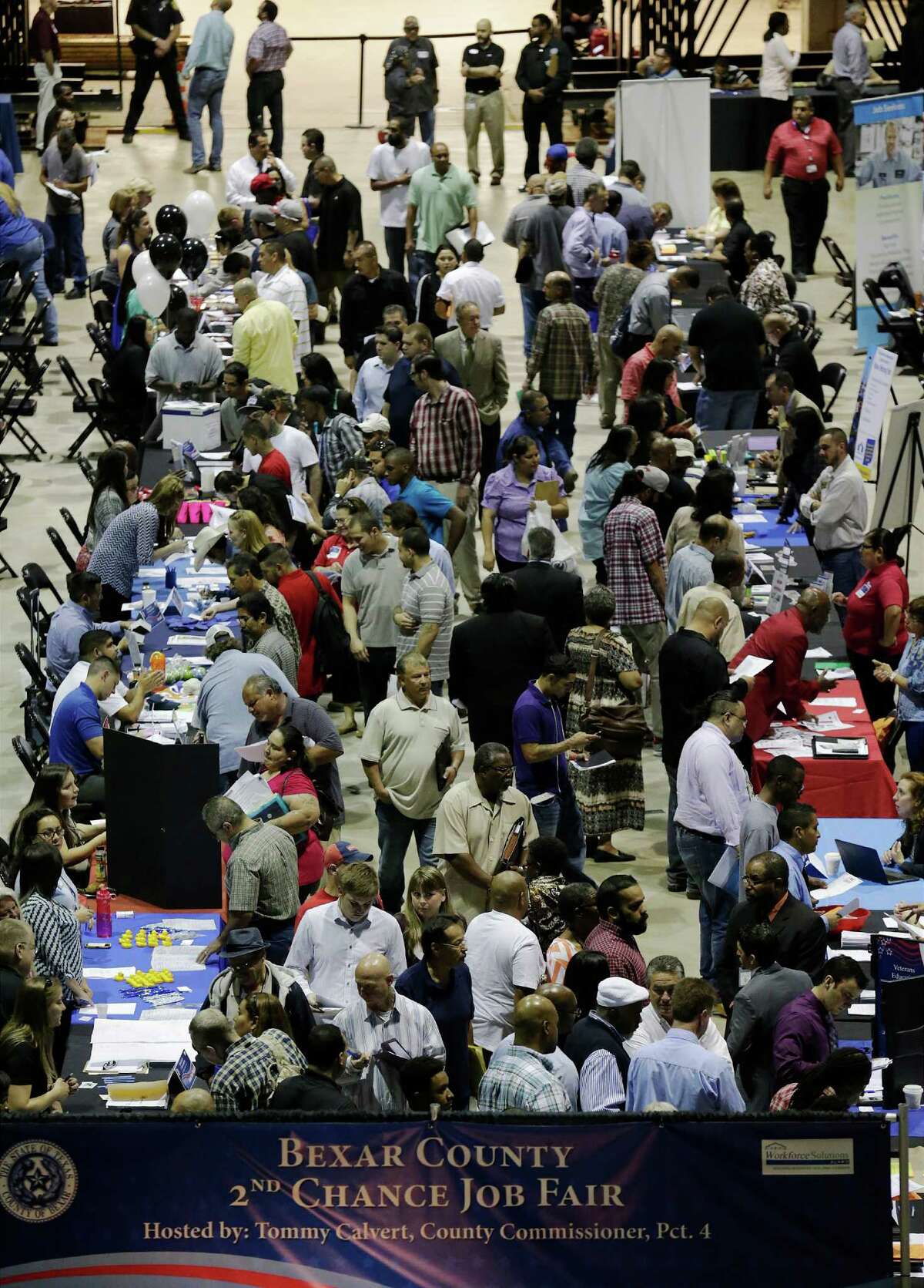 A crowd of applicants slowly make their way from table to table in search of job opportunities at the 2nd Chance Job Fair hosted by Bexar County Commissioner Tommy Calvert on Thursday at the AT&T Center.