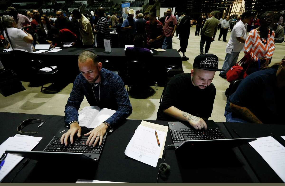 Kenneth Franklin (left) and John Luis work on their résumés on laptops provided by Workforce Solutions Alamo at the 2nd Chance Job Fair. About 70 exhibitors were on site and more than 1,500 applicants sought work at the three-hour-long event.