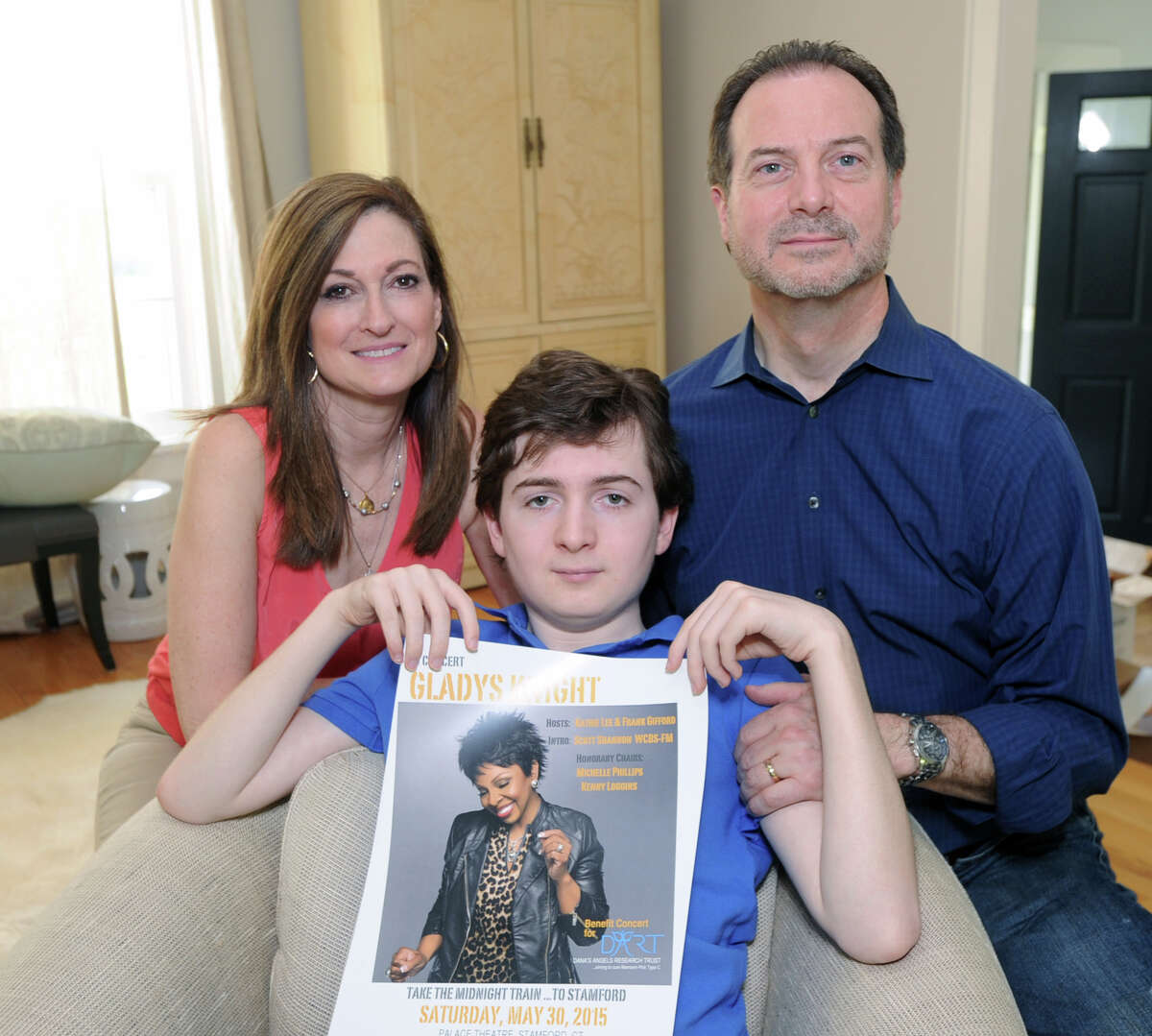Phil and Andrea Marella with their son, Andrew Marella, 15, holding a Gladys Knight poster at their Greenwich home, Friday, May 8, 2015. Andrew Marella suffers from Niemann-Pick Type C, a genetic disease that is a neurodegenerative disorder which causes progressive deterioration of the nervous system. The family who also lost a daughter, Dana, to the disorder, is spearheading a benefit gala featuring Kinght at the Palace Theatre in Stamford on Saturday, May 30, to raise money and awareness for medical research of Niemann-Pick Type C.