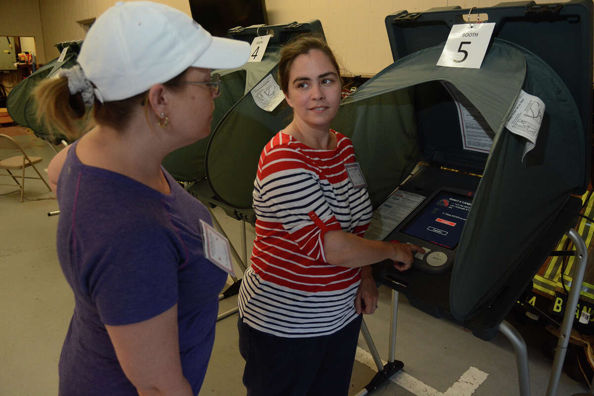Shelly Rollins, from left, poll worker, and Chelsea Taylor, Alternate Election Judge at the polling location for Precincts 32, 45 & 84 at the Timber Lakes/Timber Ridge Fire Station in Spring, check out the voting machines before opening the polling location on Saturday, May 9, 2015.