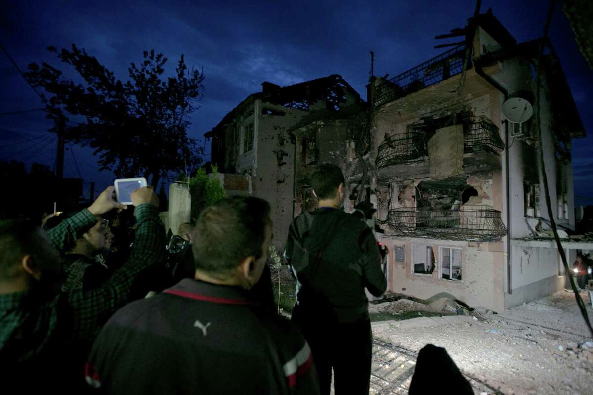 Residents visit the area were a battle took place involving the police and an armed group in the northern Macedonian town of Kumanovo. Fighting between police forces and members of an armed group has ended after two days, leaving eight police officers and 14 militants dead.