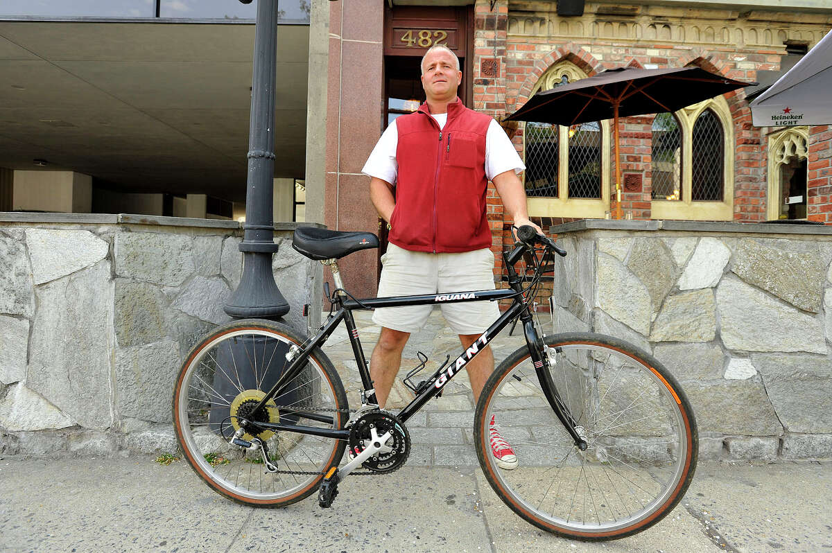 John Robert, with Rippowam Labs, shows off the main bike he takes to his workplace on Summer Street in downtown Stamford, Conn., on Monday, May 11, 2015. From time to time he takes to work a custom-made bike that his friend made.