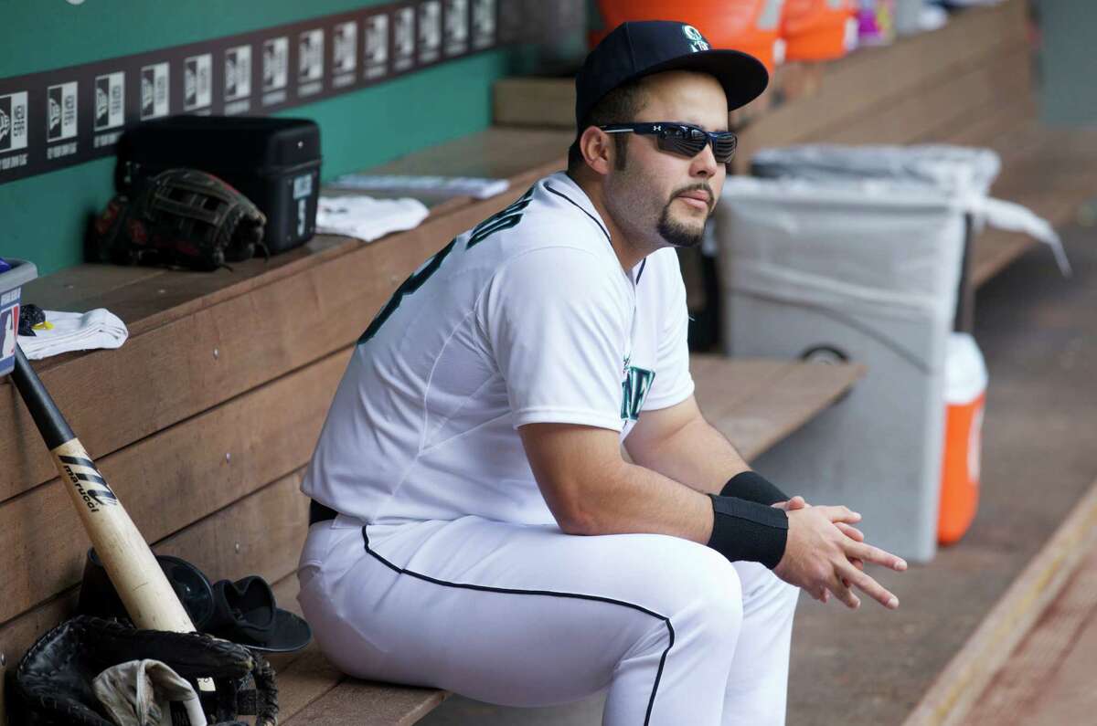 Seattle Mariners' Jesus Montero sits in the dugout before a baseball game against the San Diego Padres in Seattle, Tuesday, June 17, 2014.