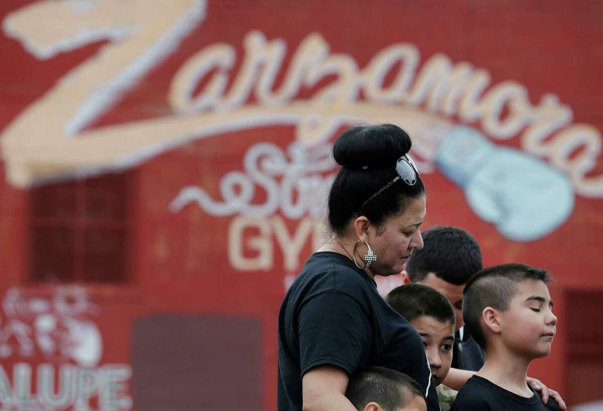 Normajean Sturgeon along with her sons Eduardo Casanova (from right), David Gonzales and Elias reflect on the passing of local boxing legend Tony Ayala, Jr. in front of Zarzamora Street Gym on Tuesday, May 12, 2015. News spread of Ayala’s death throughout the regulars who trained at the gym that Ayala and his father, Tony Ayala, Sr., started in the 1980s. The 52-year-old former boxer was found deceased in the gym.