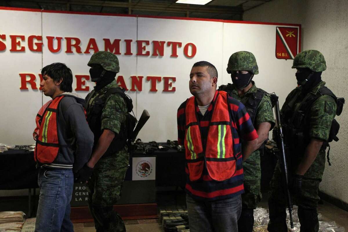 Mexican army soldiers take away Jose Guadalupe Serna Padilla, aka "El Zopilote" or "The Vulture", center, and his alleged accomplice Oscar Pozos Jimenez, left, during a presentation to the press in Zapopan, on the outskirts of Guadalajara, Mexico Sunday March 18, 2012. According to the Mexican army, Padilla is an alleged top ranking member of the Jalisco New Generation Cartel. Click through to learn more about the CJNG, which has seized power in Mexico in recent years.