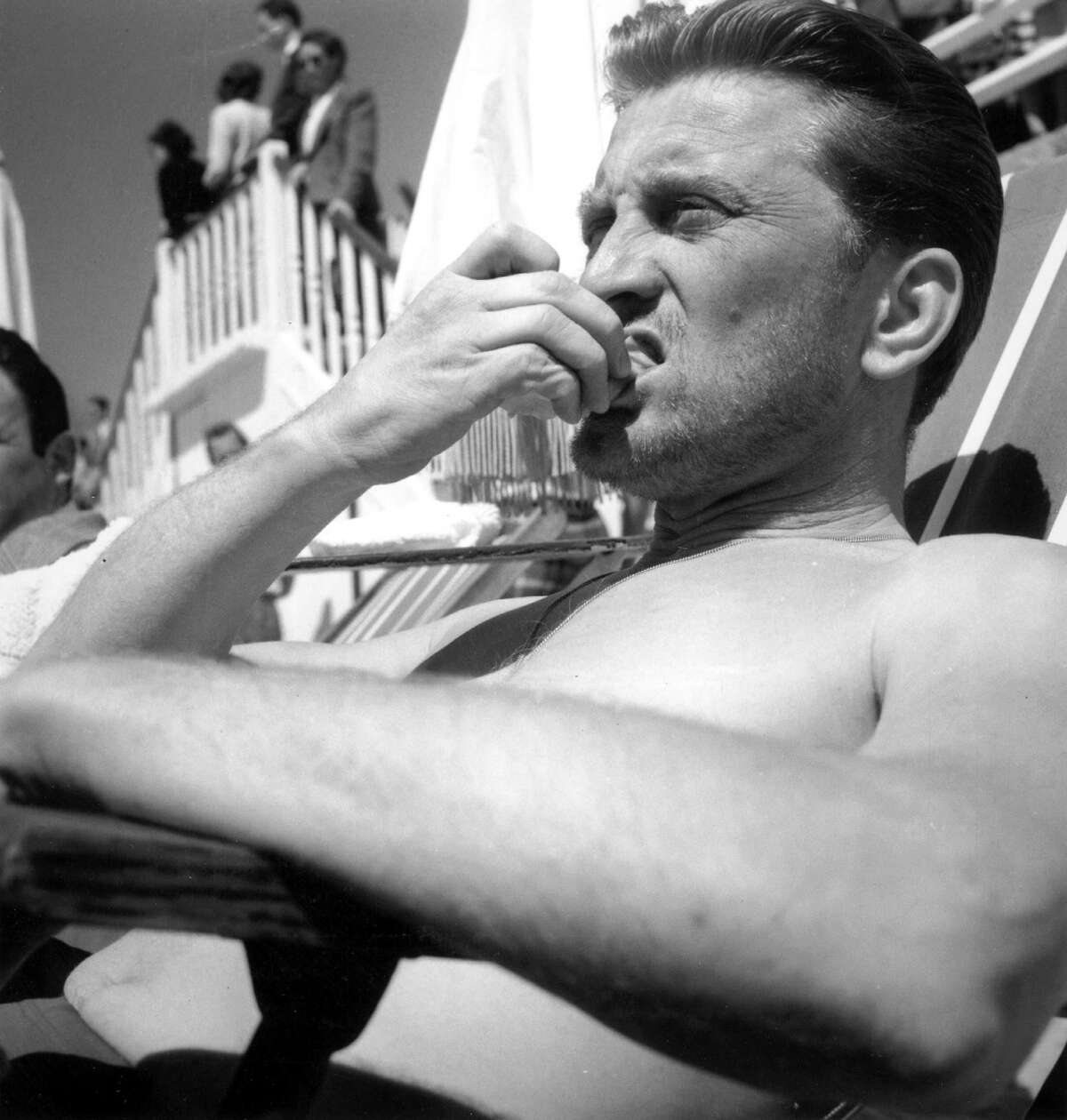 American actor Kirk Douglas relaxes on the beach during the Cannes Film Festival, 18th April 1953.