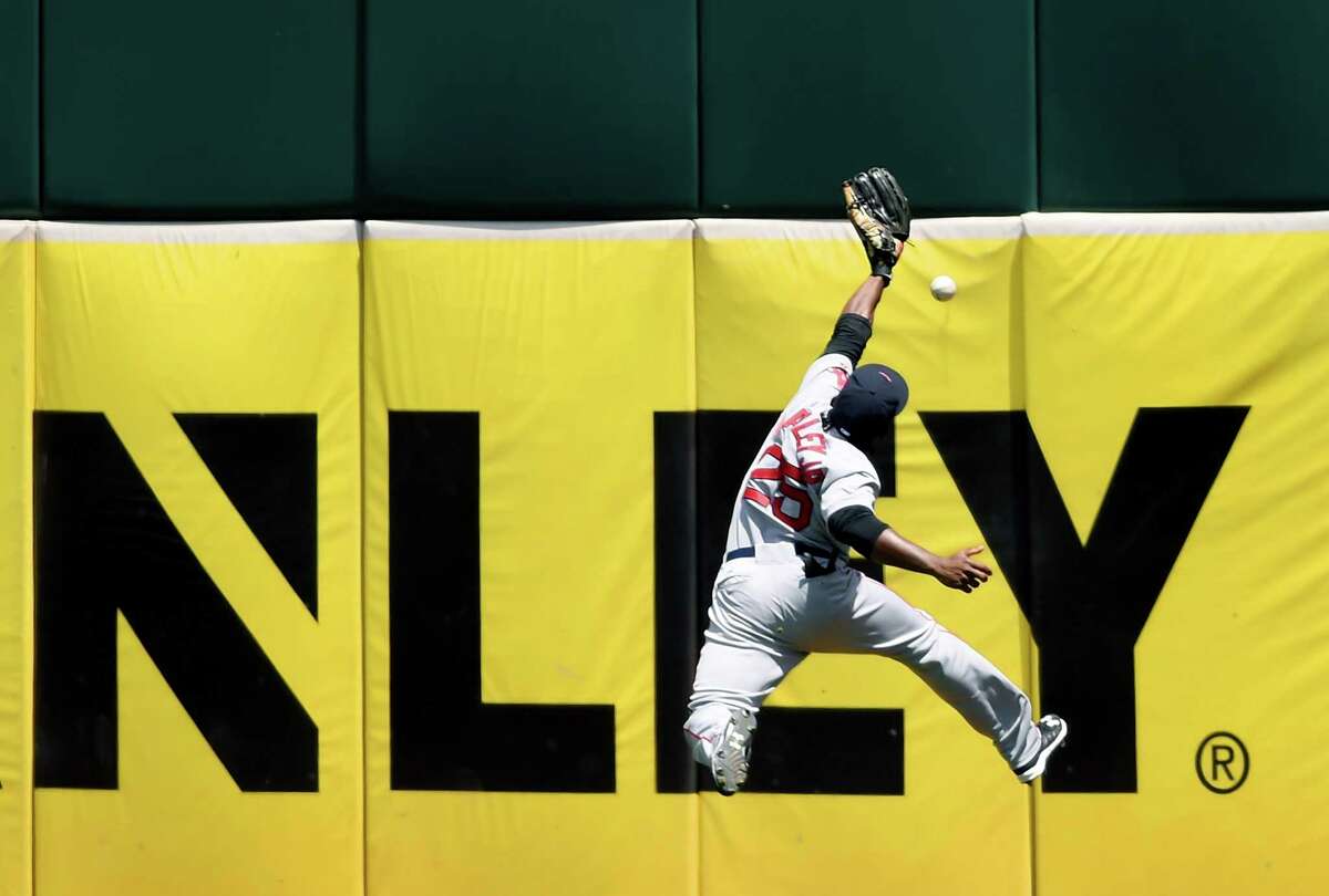 OAKLAND, CA - MAY 13: Jackie Bradley Jr. #25 of the Boston Red Sox leaps at the wall but can't make the catch of this ball that goes for a double off the bat of Josh Phegley #19 of the Oakland Athletics in the bottom of the fourth inning at O.co Coliseum on May 13, 2015 in Oakland, California. (Photo by Thearon W. Henderson/Getty Images)