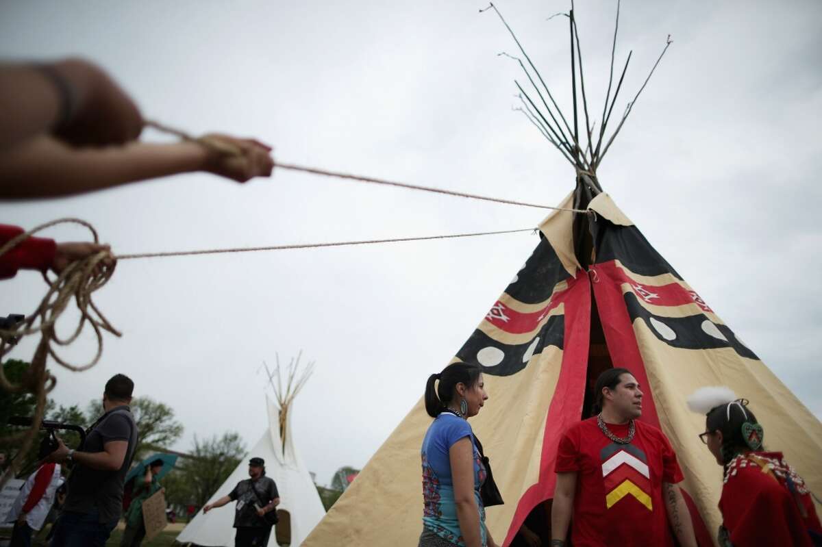 WASHINGTON, DC - APRIL 22: Native Americans from various tribes work together to erect a large tepee as part of a demonstration against the proposed Keystone XL pipeline on the National Mall April 22, 2014 in Washington, DC. As part of its "Reject and Protect" protest, the Cowboy and Indian Alliance is organizing a weeklong series of actions by farmers, ranchers and tribes to show their opposition to the pipeline. (Photo by Chip Somodevilla/Getty Images)