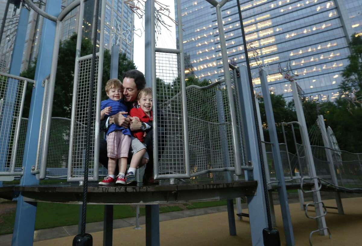 Danny David and sons Leo, left, and Elliott play at Discovery Green. The David family lives downtown.
