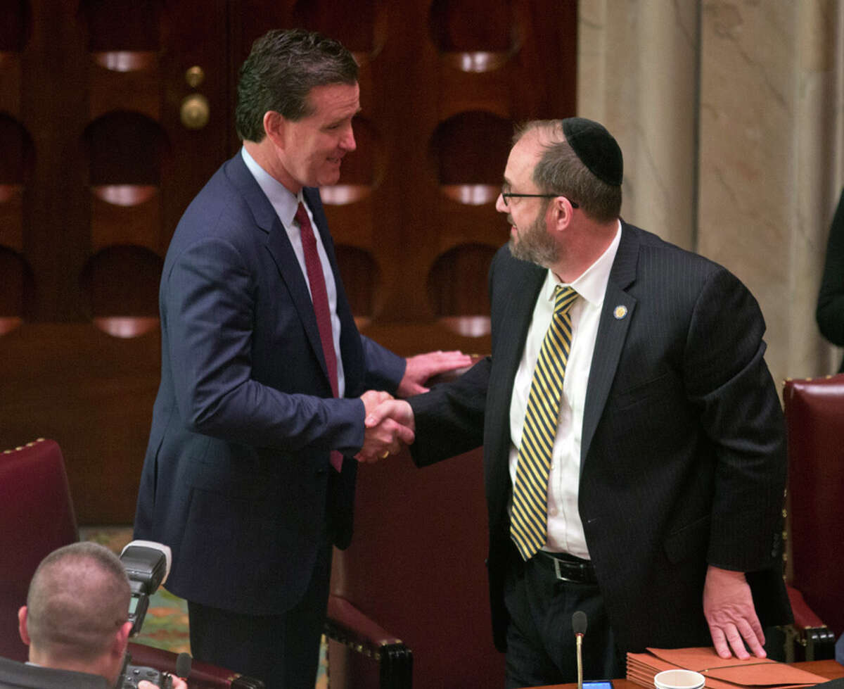New Senate Majority Leader John Flanagan, R-Smithtown, left, talks with Sen. Simcha Felder, D-Brooklyn, in the Senate Chamber at the Capitol on Monday, May 11, 2015, in Albany, N.Y. Flanagan replaces Republican Dean Skelos who resigned his position as leader following his arrest on federal corruption charges. (AP Photo/Mike Groll) ORG XMIT: NYMG111