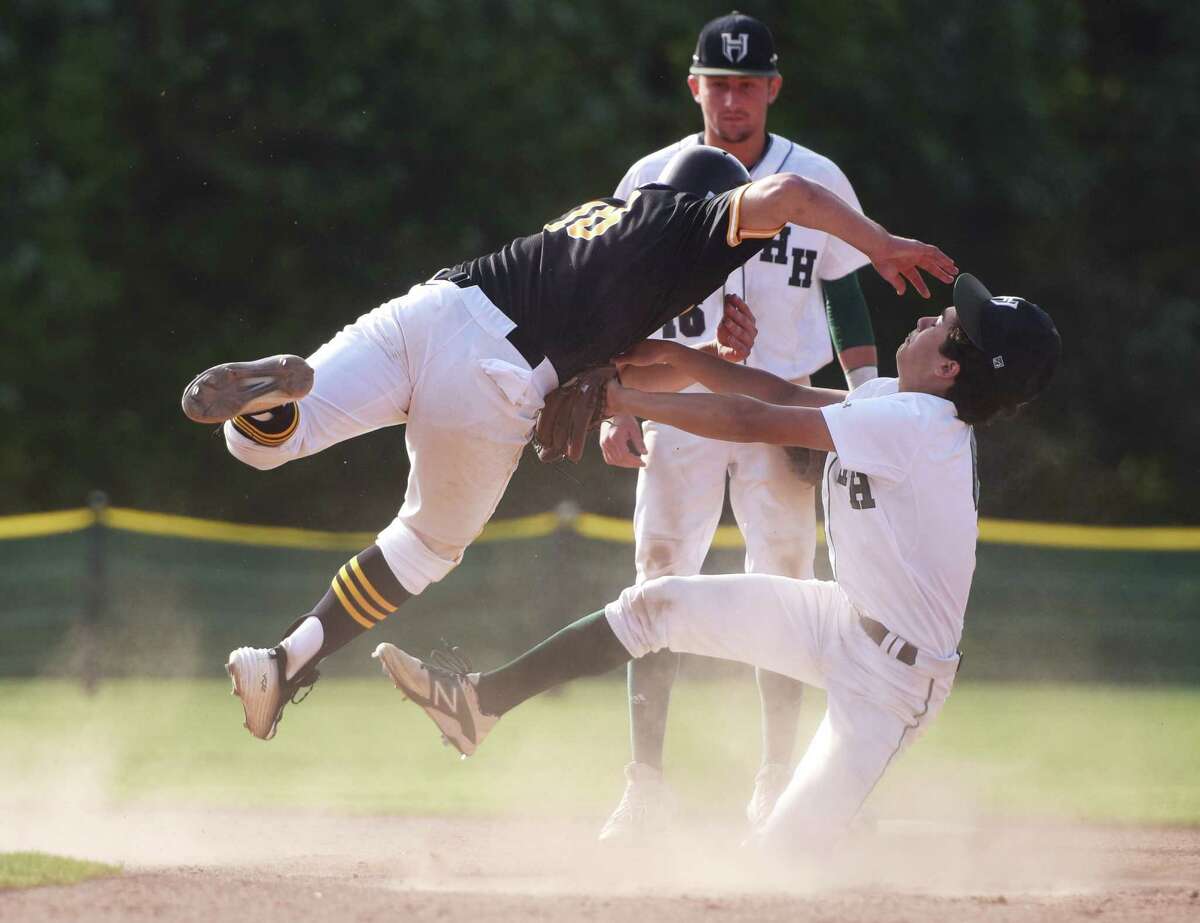 Brunswick baserunner Will Salamon (18) jumps attempting to avoid a tag from Hamden Hall second baseman Marco Fontana (4) in Brunswick's 3-0 win over Hamden Hall in the FAA baseball championship game at Brunswick School in Greenwich, Conn. Friday, May 15, 2015.