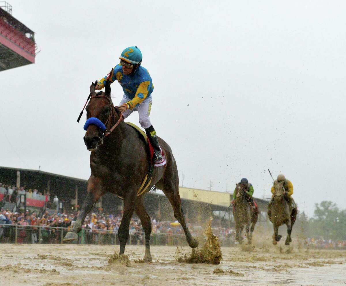 American Pharaoh with jockey Victor Espinoza flies across a very muddy track to win the 140th running of the Preakness Stakes held at Pimlico Race Course Saturday evening May 16, 2015 in Baltimore, Md. The thoroughbred, the 12th Triple Crown winner in history, was elected to National Museum of Racing and Hall of Fame on Wednesday.  (Skip Dickstein/Times Union)
