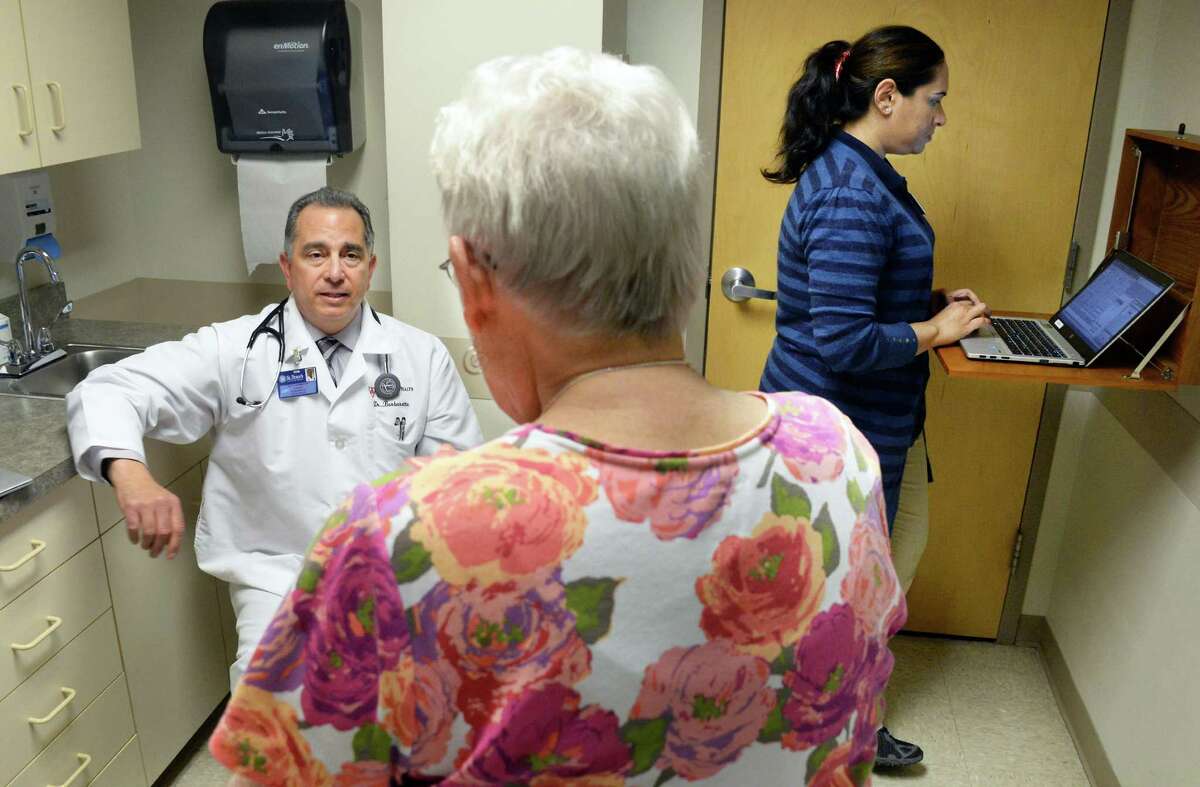 Dr. Paul Barbarotto, left, and medical scribe Saima Akhter with patient Leslie Palmer, center, during an exam at Capital Region Family Health Wednesday May 6, 2015 in Rensselaer, NY. (John Carl D'Annibale / Times Union)