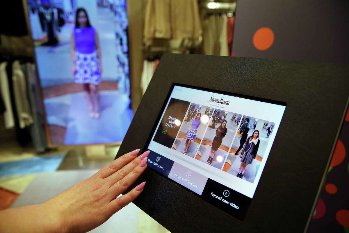 Sales manager Alysa Stefani uses a touch-screen display to make selections while demonstrating the MemoryMirror.