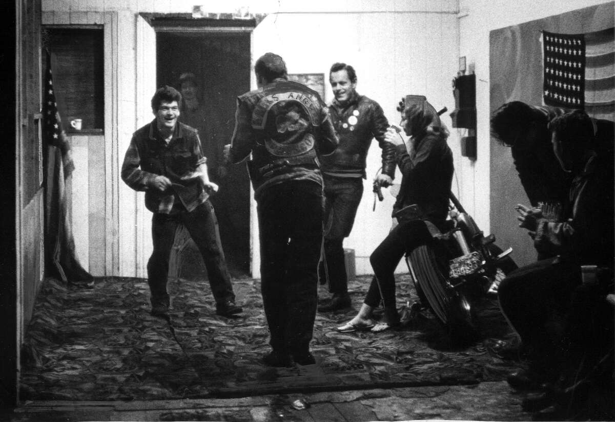Hells Angels members at their club house at 1940 East 14th St., in Oakland, CA. Men and women hang around drinking bear, smoking, and general rough housing in the cold, dark, graffiti covered abandoned building. Photo by Peter Breinig