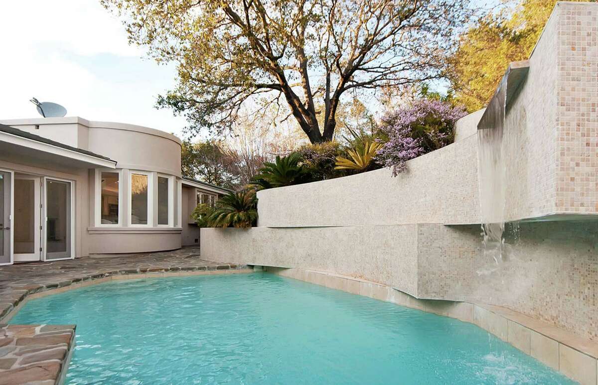 The pool is fed by a waterfall flanked by built-in planters.