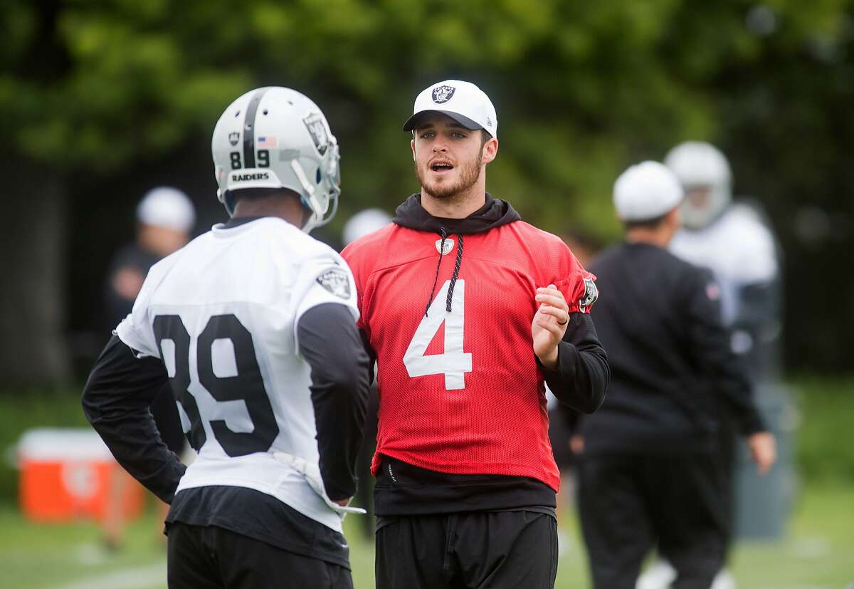 Derek Carr, right, speaks with Amari Cooper during an Oakland Raiders workout on Tuesday, May 19, 2015, in Alameda, Calif. (AP Photo/Noah Berger)