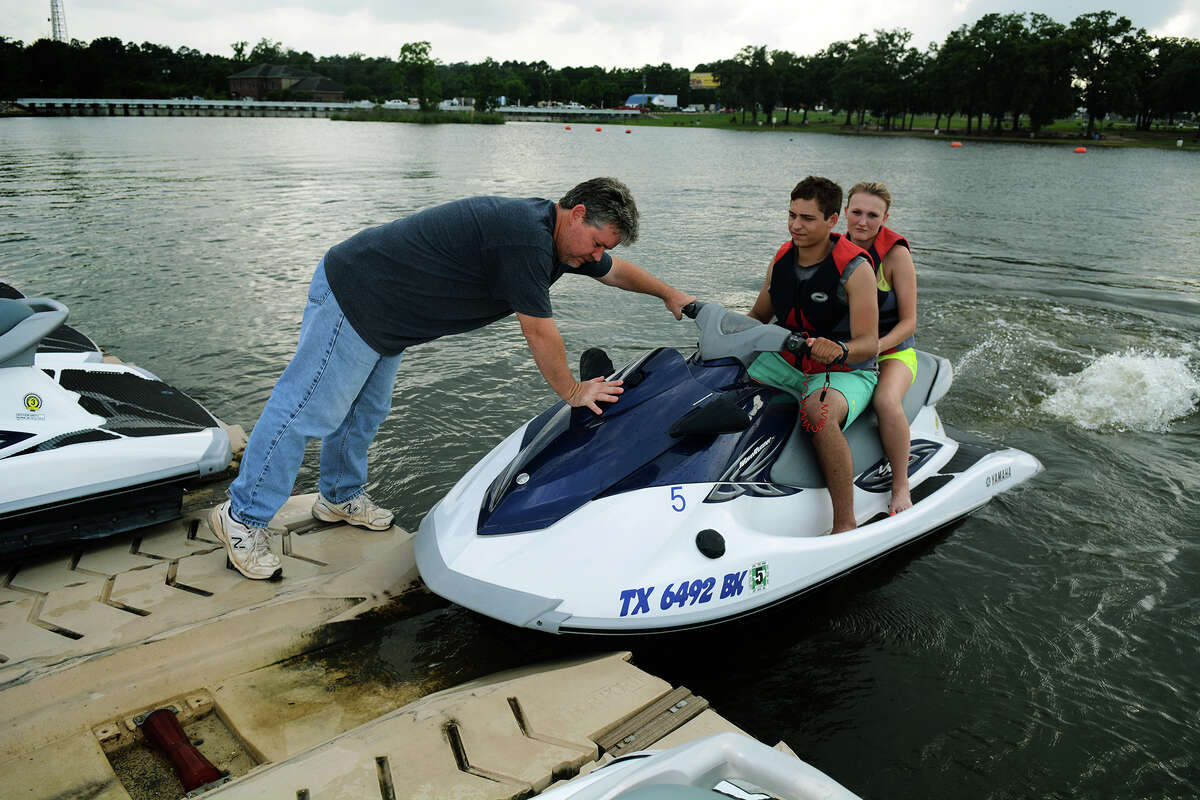 Don Beckham of Lake Conroe Water Sports,helps customers. Some lake residents oppose plans to use the lake for area water needs.