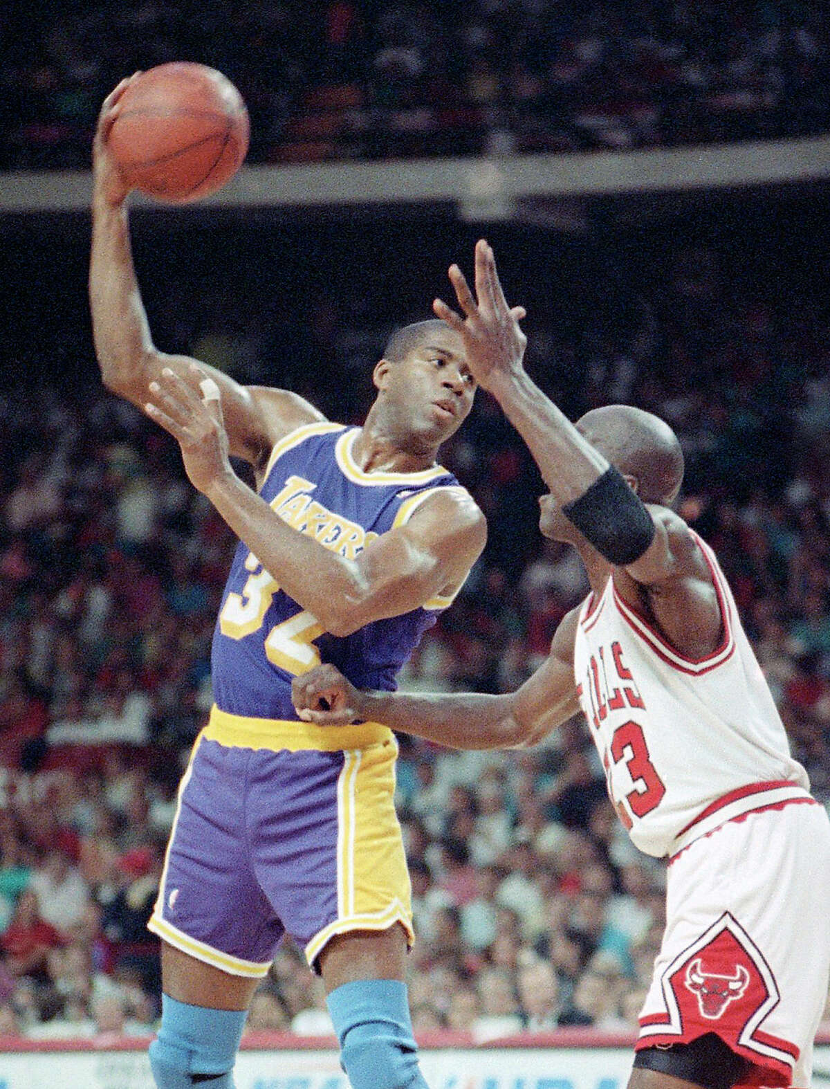 FILE - In this June 3, 1991, file photo, Los Angeles Lakers guard Magic Johnson looks to pass against Chicago Bulls' Michael Jordan during the first quarter in Game 1 of the NBA Finals in Chicago. From 1957 to 1990, the trio of Bob Cousy, Magic Johnson and Isiah Thomas combined for 13 NBA titles. They were all capable scorers, but more often than not beat opponents by setting up teammates. (AP Photo/Fred Jewell, File)