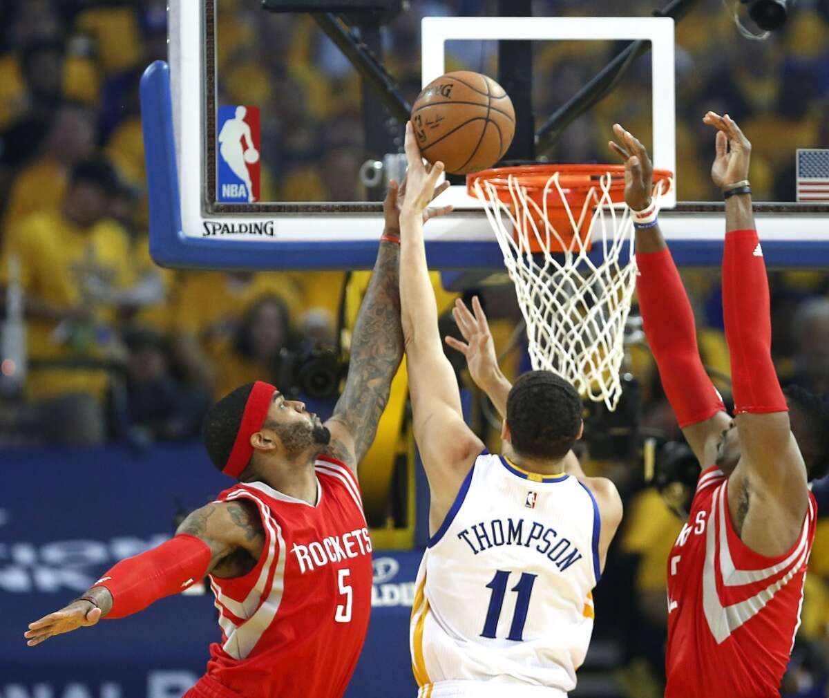 Houston Rockets forward Josh Smith (5) and center Dwight Howard (12) defend a shot by Golden State Warriors guard Klay Thompson (11) in the first period of Game 1 of the NBA Western Conference Finals at Oracle Arena on Tuesday, May 19, 2015, in Oakland. ( James Nielsen / Houston Chronicle )