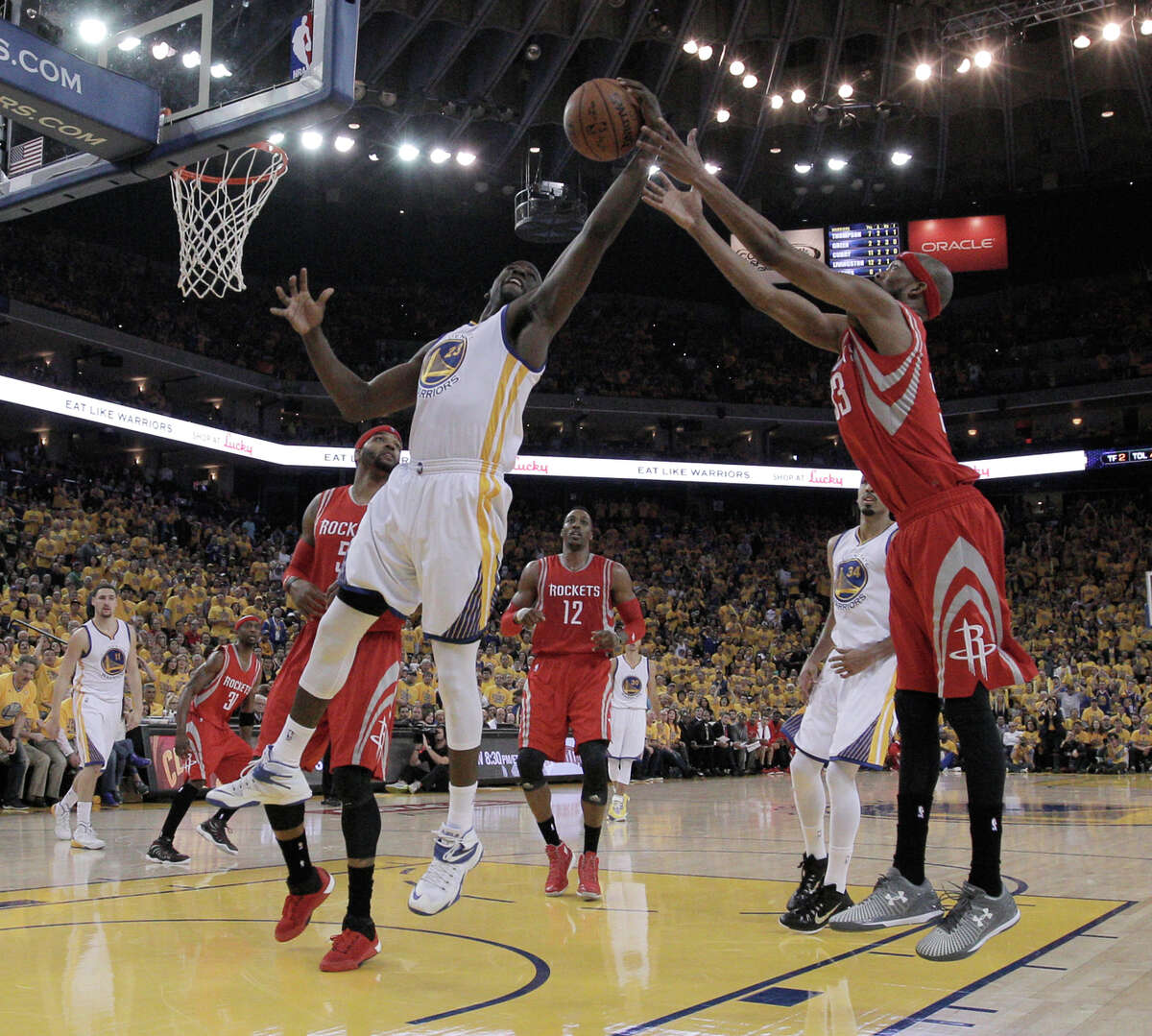 Warrior Draymond Green (23) and Rockets Corey Brewer go after a rebound during Game 1 of the Western Conference Finals on Tuesday, May 19, 2015 in Oakland, Calif.