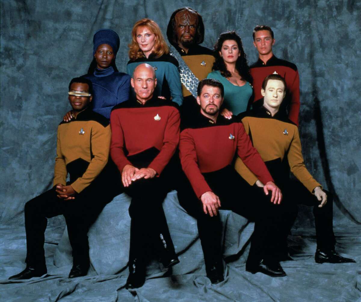 Promotional portrait of the cast of 'Star Trek: The Next Generation,' California, 1987. Pictured are from left, front row, American actor LeVar Burton (as Lieutenant Commander Geordi La Forge), British actor Patrick Stewart (as Captain Jean-Luc Picard), and American actors Jonathan Frakes (as Commander William T. Riker) and Brent Spiner (as Lieutenant Commander Data); from left, back row, American actors Whoopi Goldberg (as Guinan), Gates McFadden (as Doctor Beverly Crusher), and Michael Dorn (as Lieutenant Worf), British-American actress Marina Sirtis (as Counselor Deanna Troi), and American actor Wil Wheaton (as Wesley Crusher).