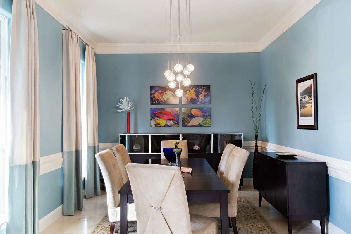 The living room, once dark green with burgandy curtains, now has light blue walls and an open feel. Designer Ariana Smetana had the curtains custom made with blue and cream color blocking.