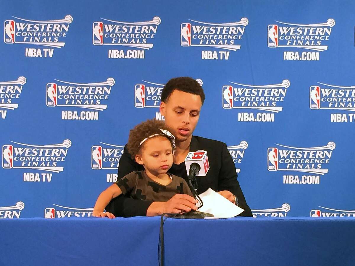 This image provided by SFBay.ca, shows Golden State Warriors' Stephen Curry with his daughter Riley during the post game press conference after the first game of their Western Conference finals of the NBA Playoffs in Oakland, California, on Tuesday, May 19, 2015. The Warriors defeated the Houston Rockets 110-106. (Sarah Todd / SFBay.ca via AP)