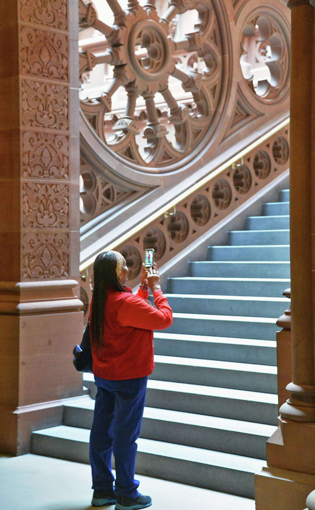 AARP care givers advocate Loraine Assent of Brooklyn takes a moment to photograph on a staircase during public advocacy day at the Capitol Tuesday May 19, 2015, in Albany, NY. (John Carl D'Annibale / Times Union)