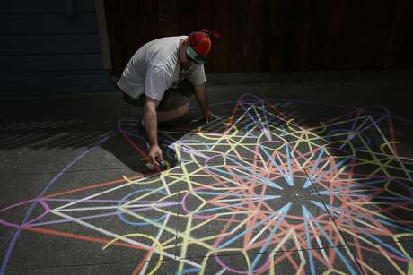 Chalk artist Nikolas Larson works on a geometric design near his home in the Mission on Friday May 18, 2015 in San Francisco, Calif.