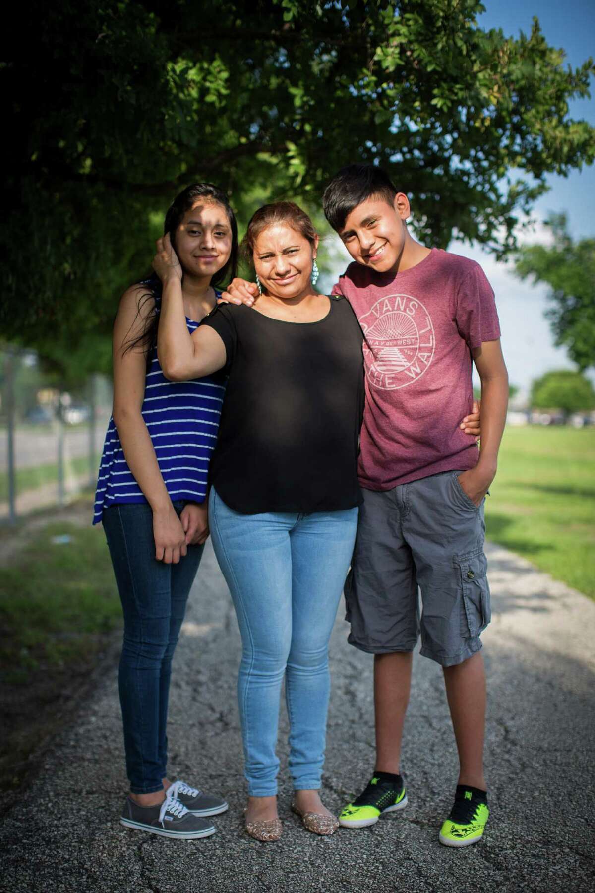 Patricia Salazar, center, 40, and her children Maykol Salazar, right, 14, and Linneth Salazar, 13, left, sit in the park near their home in Houston. Patricia Salazar came to the United States from Honduras eight years ago and sent for her children last year. Patricia Salazar works two jobs to be able to bring them and sustain them. Maykol is one of the top ESL students in his class and making all As at Lee High School despite only starting to learn English this year. Tuesday, May 19, 2015, in Houston.