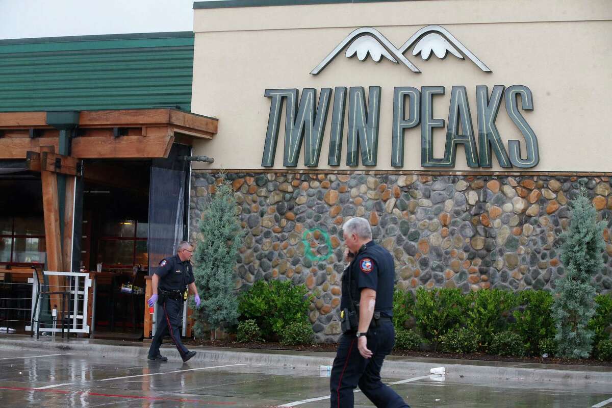 In this file photo, Waco police officers walk along the perimeter of the Twin Peaks restaurant during an investigation May 20, 2015 in Waco of a deadly shootout involving rival motorcycle gangs.