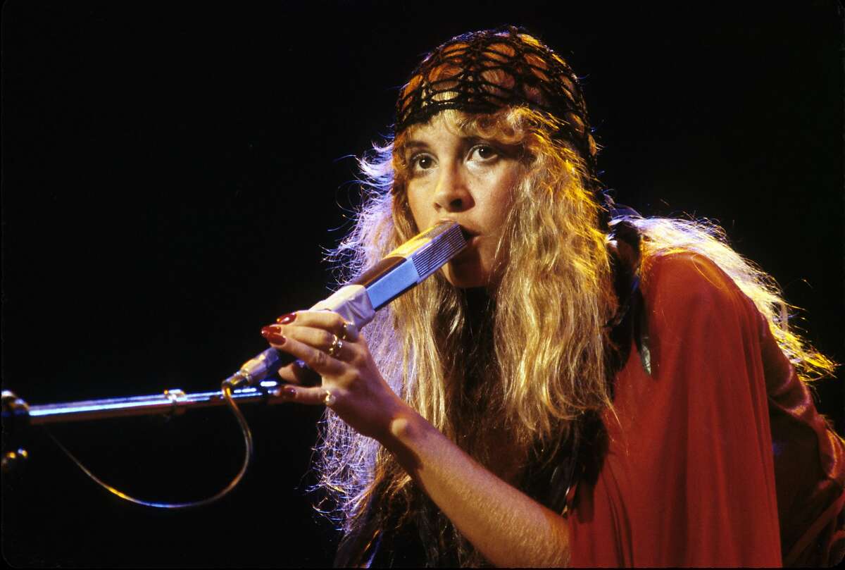 Stevie Nicks wears her signature bohemian look of flowing garments and hear wrap during a Fletwood Mac performance in 1978.