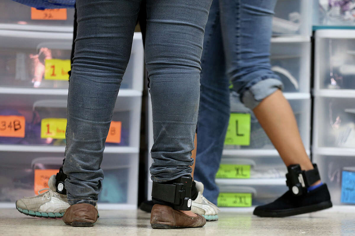 Central American immigrant women wear ankle monitors while getting clothing at the Sacred Heart Catholic Church shelter, Thursday, May 21, 2015. According to volunteers, they started noticing adult immigrants with the monitors, provided by U.S. Customs and Immigration Enforcement, on May 13. After they are processed by immigration, some of the immigrants are released on their own recognizance with a date to appear before an immigration judge at the arrival destination in the US. The monitors are used to insure that they show up before a judge according to an immigration statement.