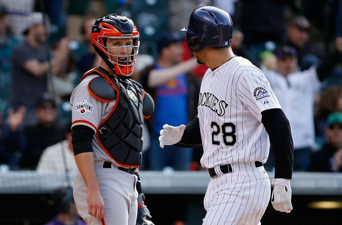 DENVER, CO - MAY 24: Nolan Arenado #28 of the Colorado Rockies has words with catcher Buster Posey #28 of the San Francisco Giants as he scores on his three run home run off of Jean Machi #63 of the San Francisco Giants to give the Rockies a 9-0 lead in the fourth inning at Coors Field on May 24, 2015 in Denver, Colorado. (Photo by Doug Pensinger/Getty Images)
