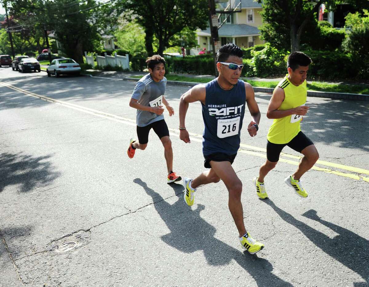 Race leaders Angel Confesor, left, of Brooklyn, N.Y., Jesus Zamora, center, of New York City, and Alejandro Ariza, of Brooklyn, N.Y., speed up a hill during the Jim Fixx Memorial Day 5-mile road race in Greenwich, Conn. Monday, May 25, 2015. Ariza would go on to win the race with a time of 27:27, with Zamora and Confesor placing second and third. The 51st annual race, sponsored by the Department of Parks and Recreation and Threads and Treads, traversed the town going down Greenwich Avenue and through Bruce Park before finishing at the Havemeyer Field track.
