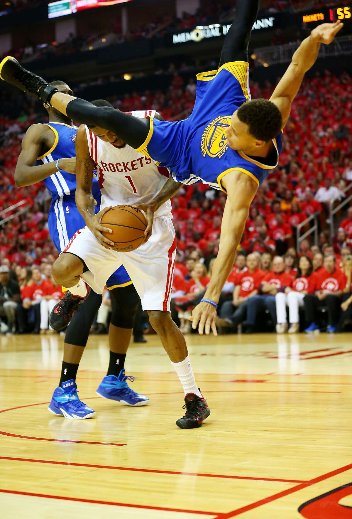 HOUSTON, TX - MAY 25: Stephen Curry #30 of the Golden State Warriors falls over Trevor Ariza #1 of the Houston Rockets on his way to an injury in the second quarter during Game Four of the Western Conference Finals of the 2015 NBA Playoffs at Toyota Center on May 25, 2015 in Houston, Texas. NOTE TO USER: User expressly acknowledges and agrees that, by downloading and or using this photograph, user is consenting to the terms and conditions of Getty Images License Agreement. (Photo by Ronald Martinez/Getty Images)