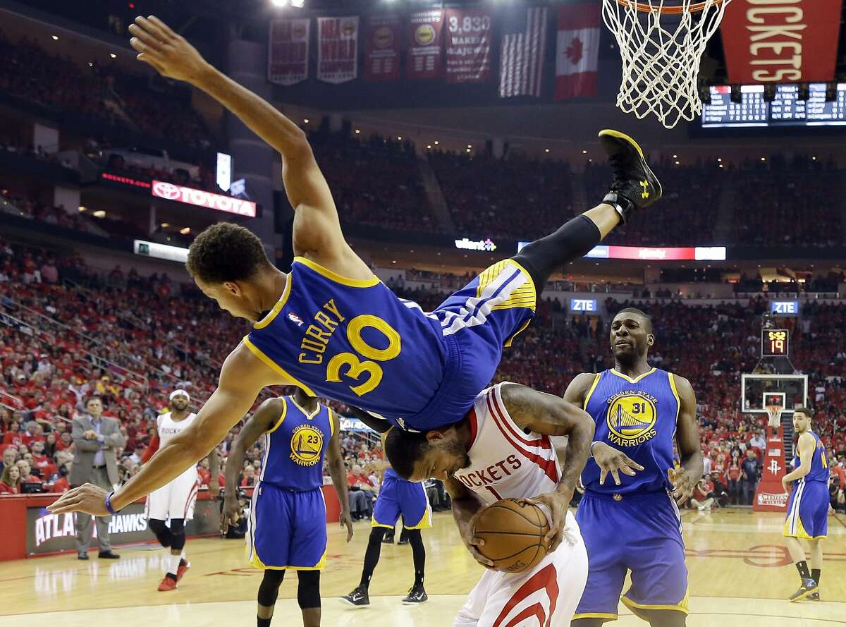 Golden State Warriors guard Stephen Curry (30) topples over Houston Rockets forward Trevor Ariza (1) during the first half in Game 4 of the Western Conference finals of the NBA basketball playoffs, Monday, May 25, 2015, in Houston. (AP Photo/David J. Phillip)