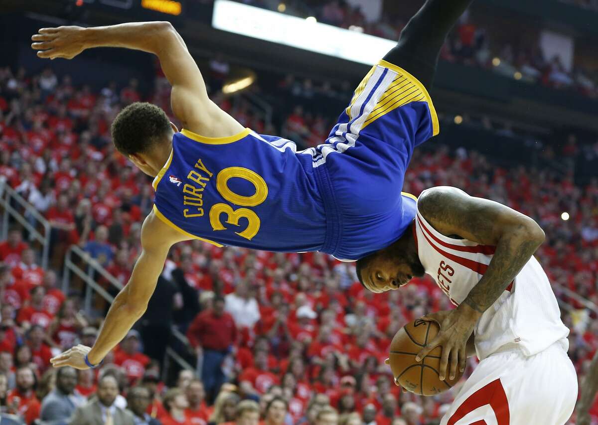 Golden State Warriors guard Stephen Curry (30) topples over Houston Rockets forward Trevor Ariza (1) during the first half in Game 4 of the Western Conference finals of the NBA basketball playoffs, Monday, May 25, 2015, in Houston. (James Nielsen/Houston Chronicle via AP)