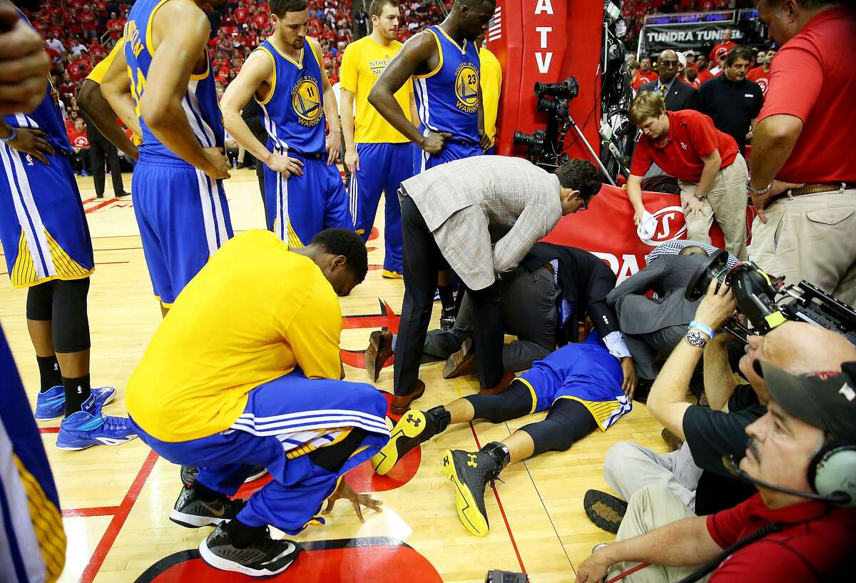 HOUSTON, TX - MAY 25: Stephen Curry #30 of the Golden State Warriors receives medical attention after falling over Trevor Ariza #1 of the Houston Rockets on his way to an injury in the second quarter during Game Four of the Western Conference Finals of the 2015 NBA Playoffs at Toyota Center on May 25, 2015 in Houston, Texas. NOTE TO USER: User expressly acknowledges and agrees that, by downloading and or using this photograph, user is consenting to the terms and conditions of Getty Images License Agreement. (Photo by Ronald Martinez/Getty Images)