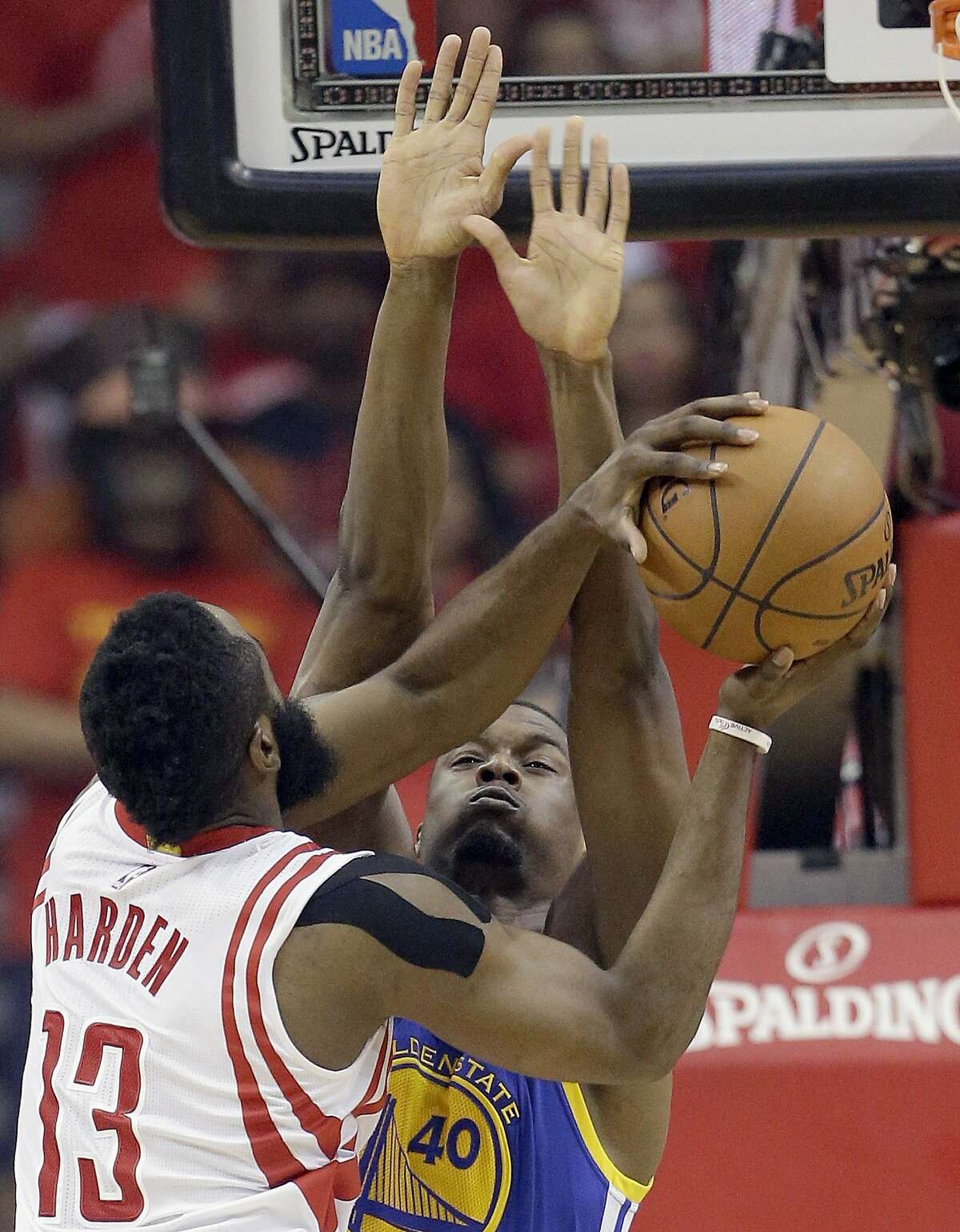 Houston Rockets guard James Harden (13) shoots as Golden State Warriors forward Harrison Barnes (40) defends during the first half in Game 4 of the NBA basketball Western Conference finals Monday, May 25, 2015, in Houston. (AP Photo/David J. Phillip)