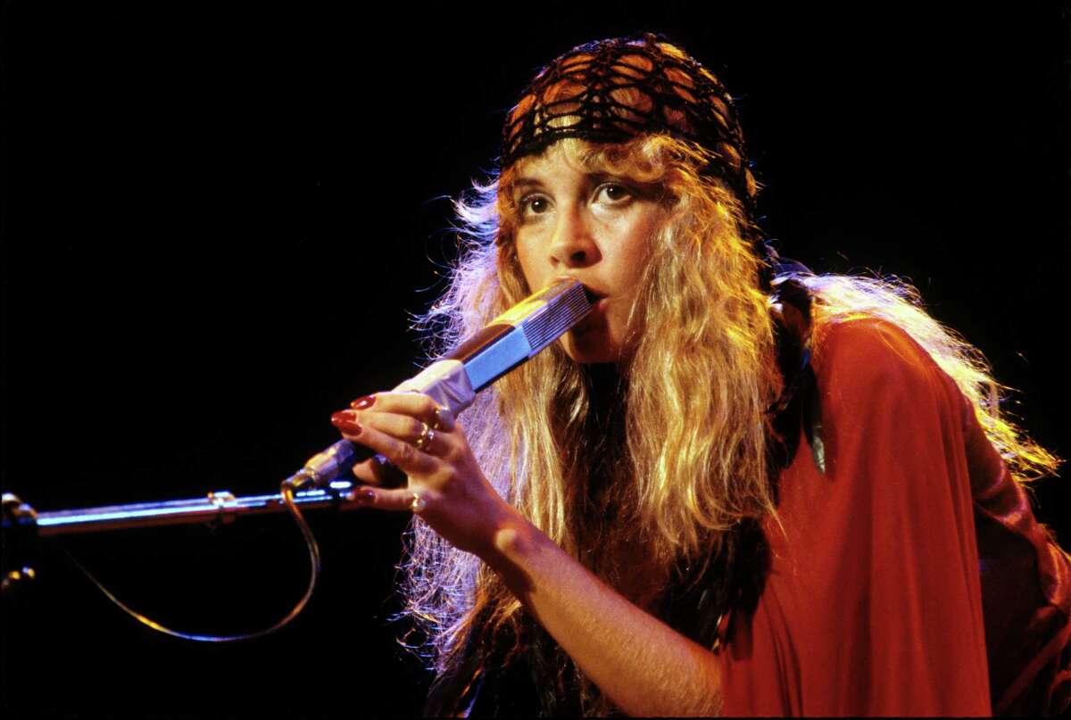 Stevie Nicks wears her signature bohemian look of flowing garments and hear wrap during a Fletwood Mac performance in 1978.