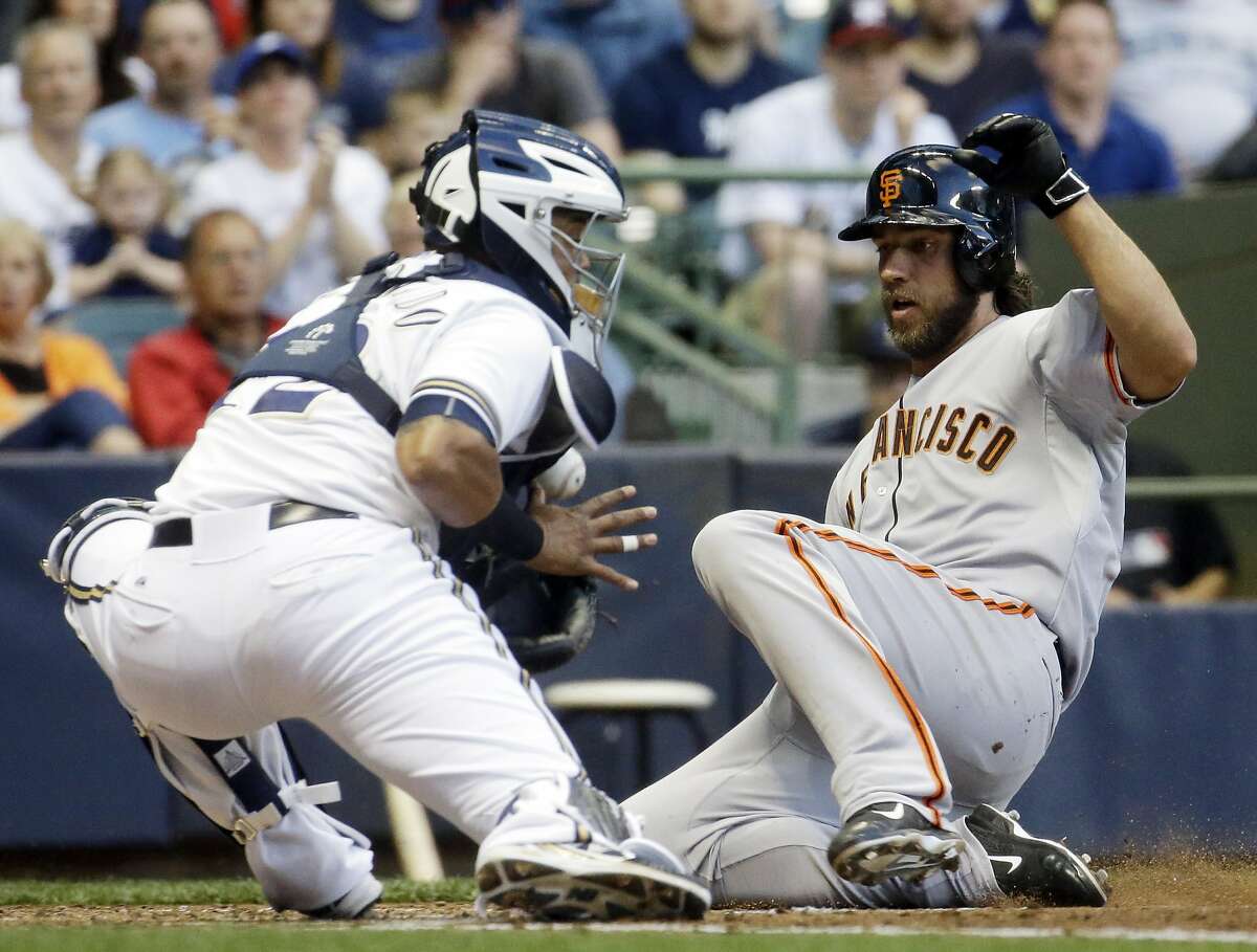 Milwaukee Brewers catcher Martin Maldonado can't handle the throw as San Francisco Giants' Madison Bumgarner slides safely home during the third inning of a baseball game Tuesday, May 26, 2015, in Milwaukee. Bumgarner scored on a hit by Joe Panik. (AP Photo/Morry Gash)
