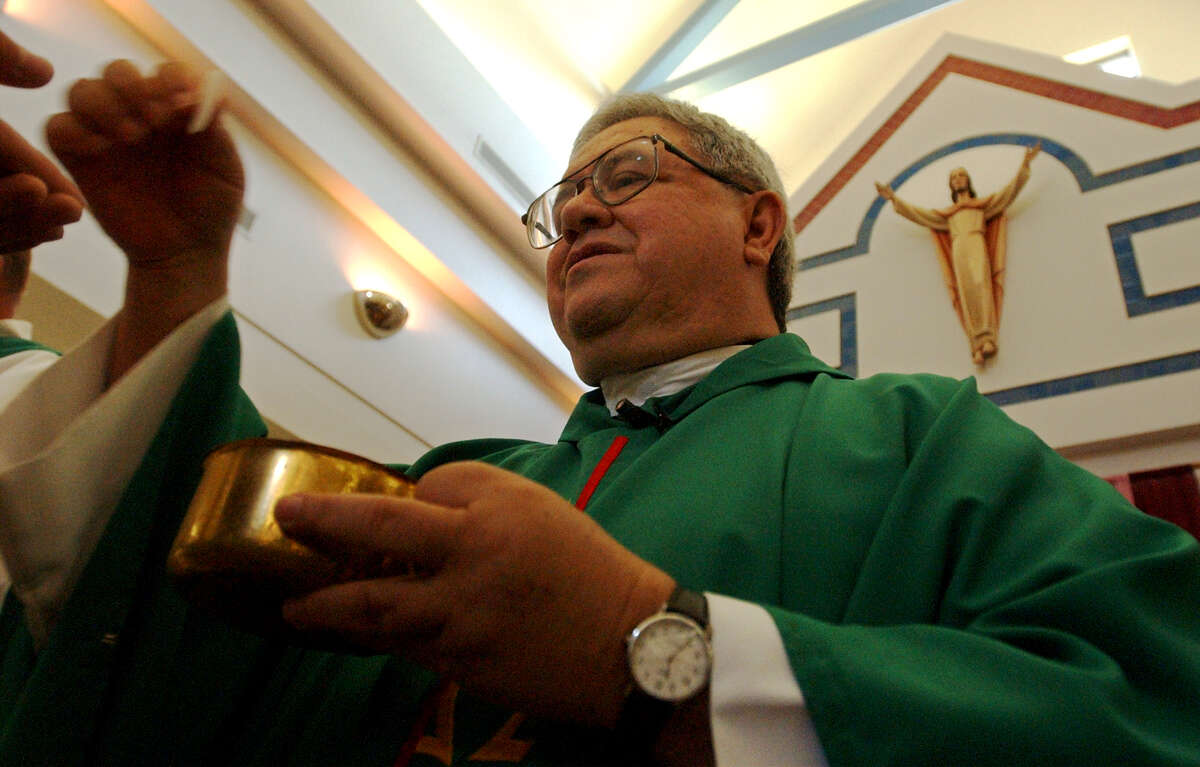 METRO Father Virgilio Elizondo hands out communion at St Rose LIma, Sunday, August 25, 2002. GLORIA FERNIZ/STAFF