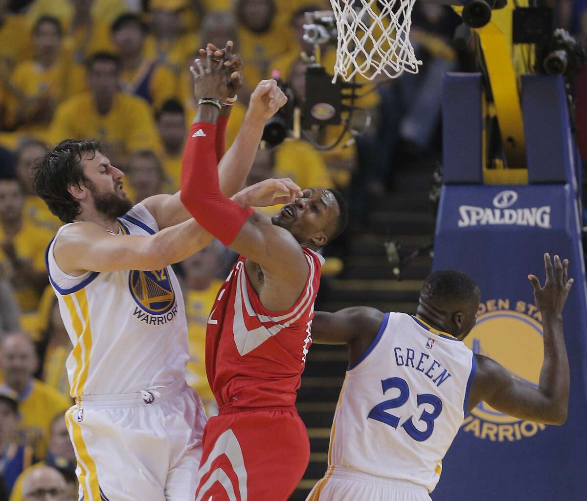 Golden State Warriors' Andrew Bogut and Houston Rockets' Dwight Howard get tangled up under the Houston basket in the first period during Game 5 of the Western Conference Finals on Wednesday, May 27, 2015 in Oakland, Calif.