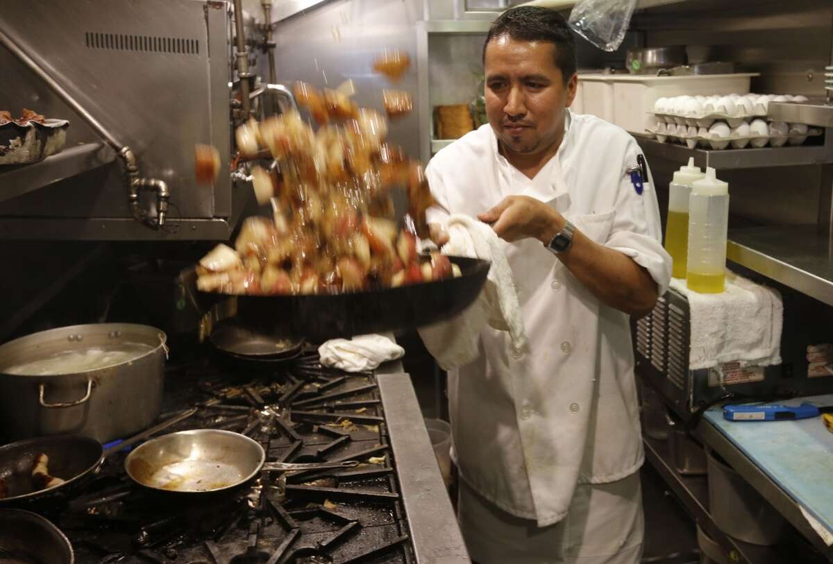 Head cook Billy Guzman prepares orders in the kitchen at Zazie restaurant, in San Francisco, Calif., on Wednesday Aug. 27, 2014.