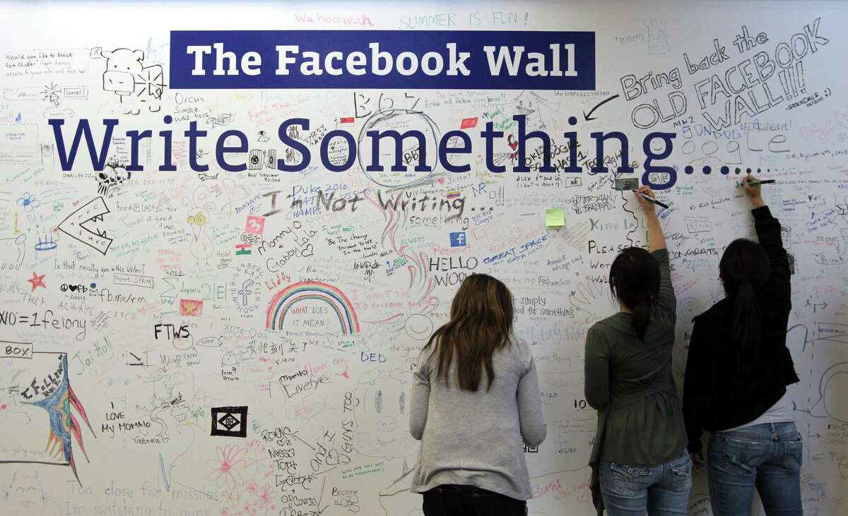 PALO ALTO, CA - AUGUST 18: Facebook employees write on the Facebook "wall" following a news conference at Facebook headquarters August 18, 2010 in Palo Alto, California. Facebook founder and CEO Mark Zuckerberg announced the launch of Facebook Places, a new application that allows Facebook users to document places they have visited.