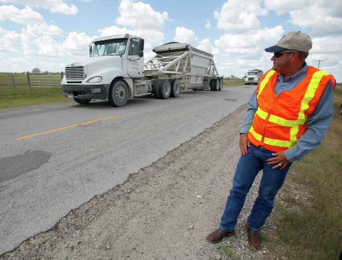 Texas Department of Transportation Executive Director retired Lt. Gen. Joe Weber watches trucks as he examines a county road in Karnes County. Nancy Beward with the state’s Disaster Recovery Program Management Team, compared the region’s infrastructure needs to the rebuilding required after a major hurricane hits.