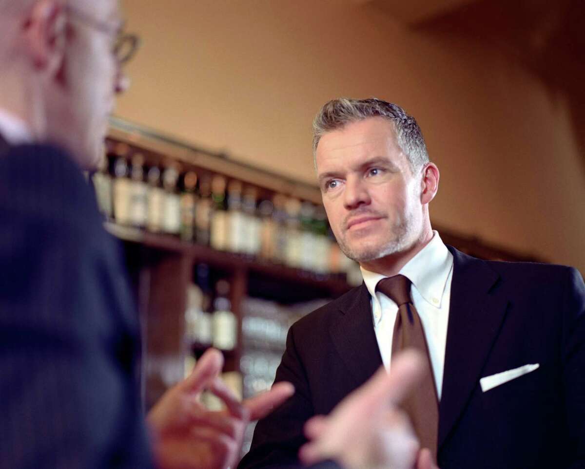 Two businessmen discussing at bar counter, side view