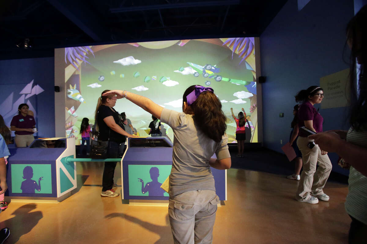 Kids direct dinosaurs on a large screen by simply moving their own arms as the DoSeum prepares for its grand opening with last minute adjustments and early kid tours on May, 19, 2015.